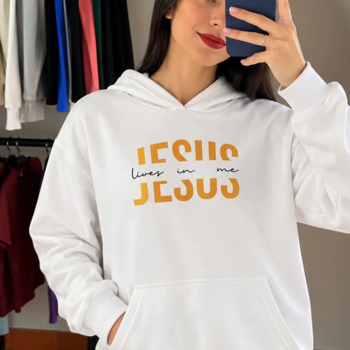 Buzo canguro de algodón Jesus lives in me, blanco (talle GG) — imagen publicada por el comercio en sus historias de Instagram @simple.indumentariia (30/10/2026), marcada como contenido de IA